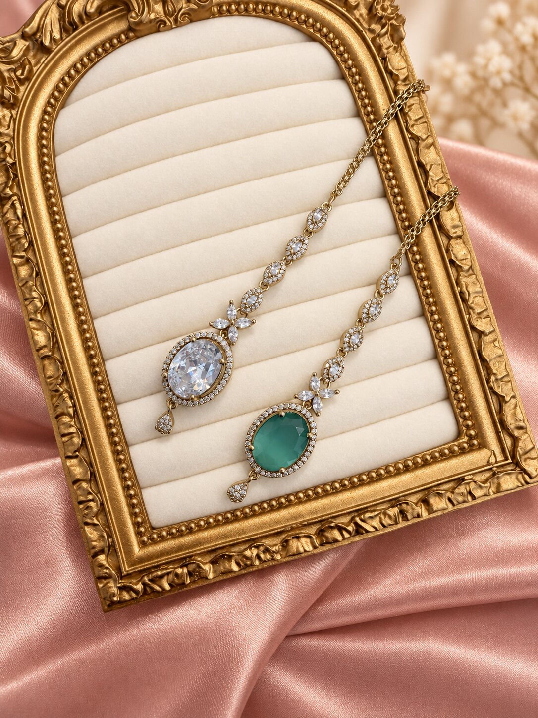 Naina oval maang tikkas in crystal clear and emerald green displayed in a gold frame